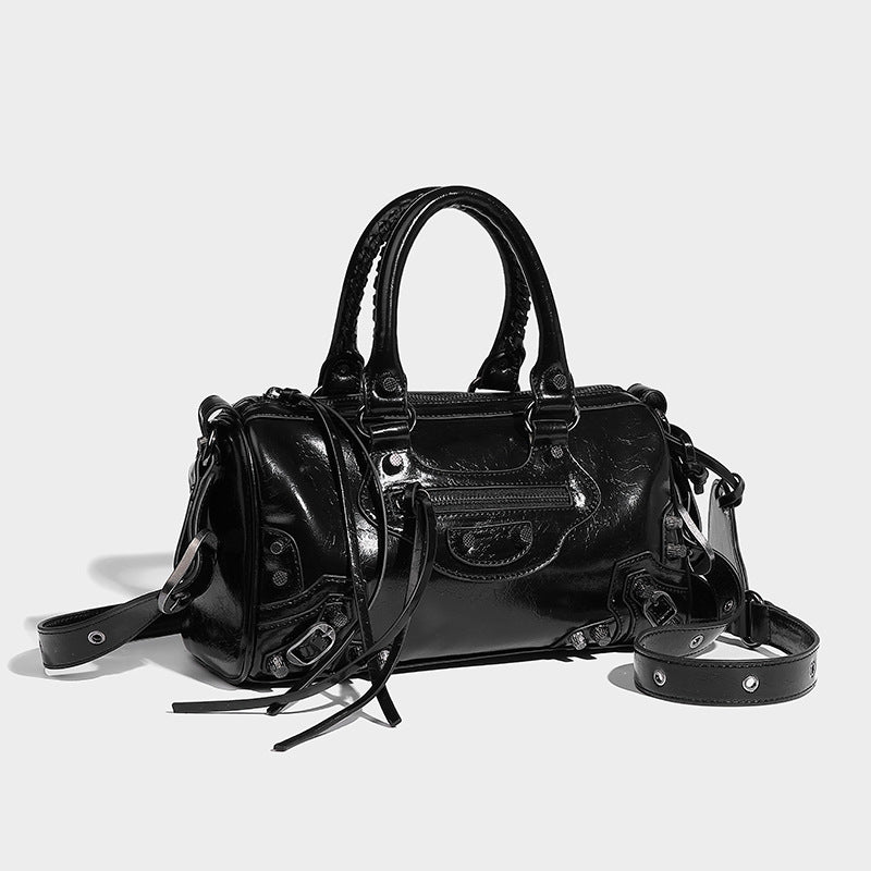 Glossy studded mini satchel bag with braided top handles, front zip pocket, heart charm, and detachable crossbody strap