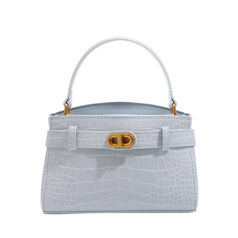 Small structured crocodile-embossed top-handle bag with gold-tone turn-lock closure and detachable shoulder strap, detail