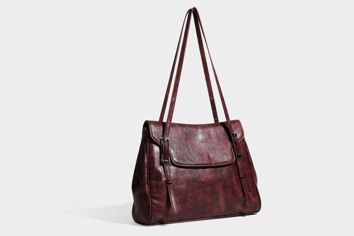 Structured flap-top shoulder tote bag in distressed leather-look finish with silver-tone buckle hardware and double shoulder