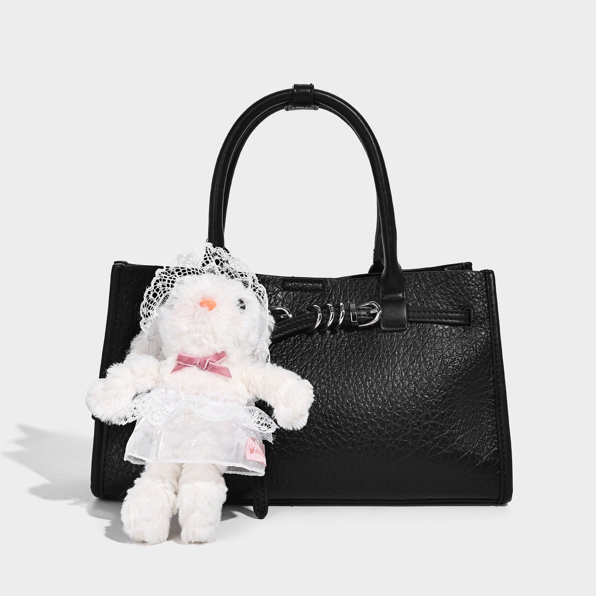 Structured trapezoid tote bag in pebbled leather-look finish with double top handles, silver-tone bar hardware, and, detail