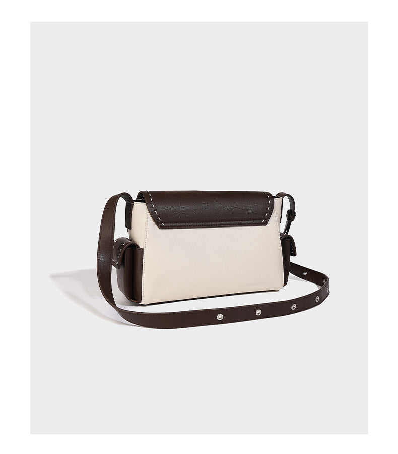 Structured flap crossbody bag in dark brown and cream color-block with white contrast stitching, adjustable shoulder strap