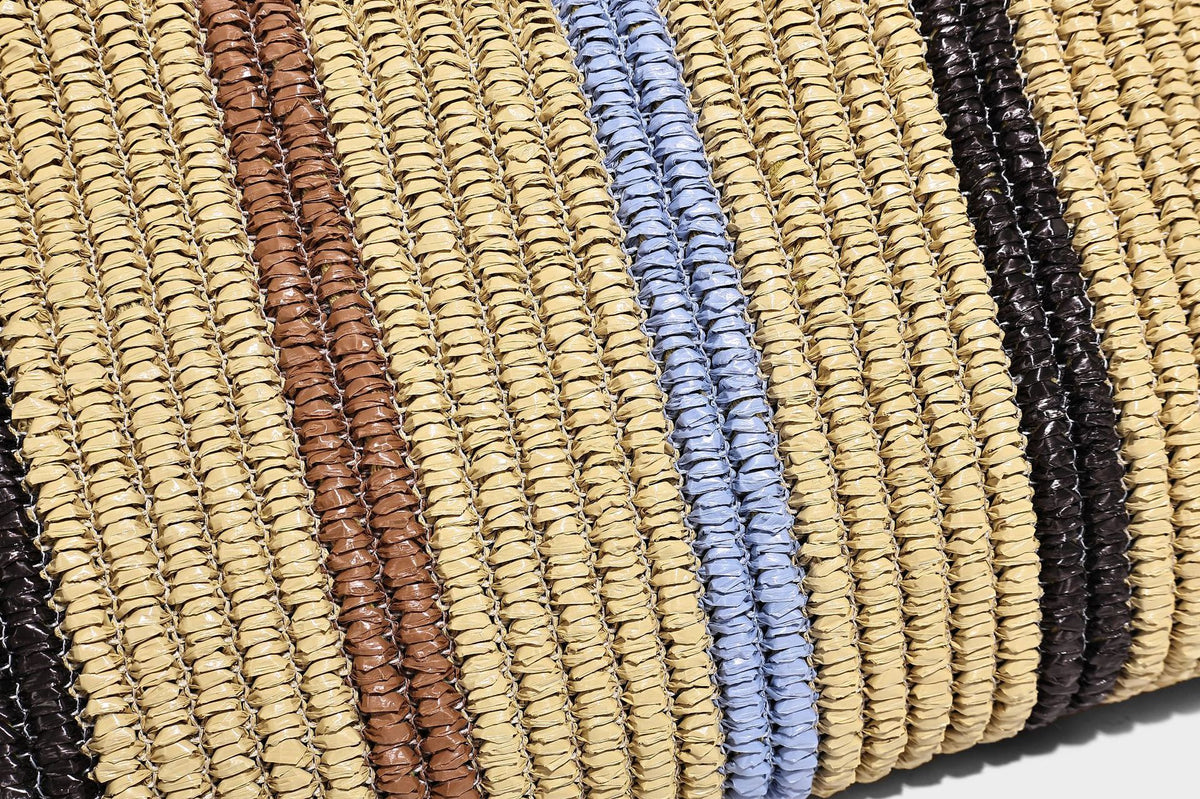 Slouchy woven straw hobo shoulder bag with beige, black, brown, and blue vertical stripes and brown leather-look trim, detail