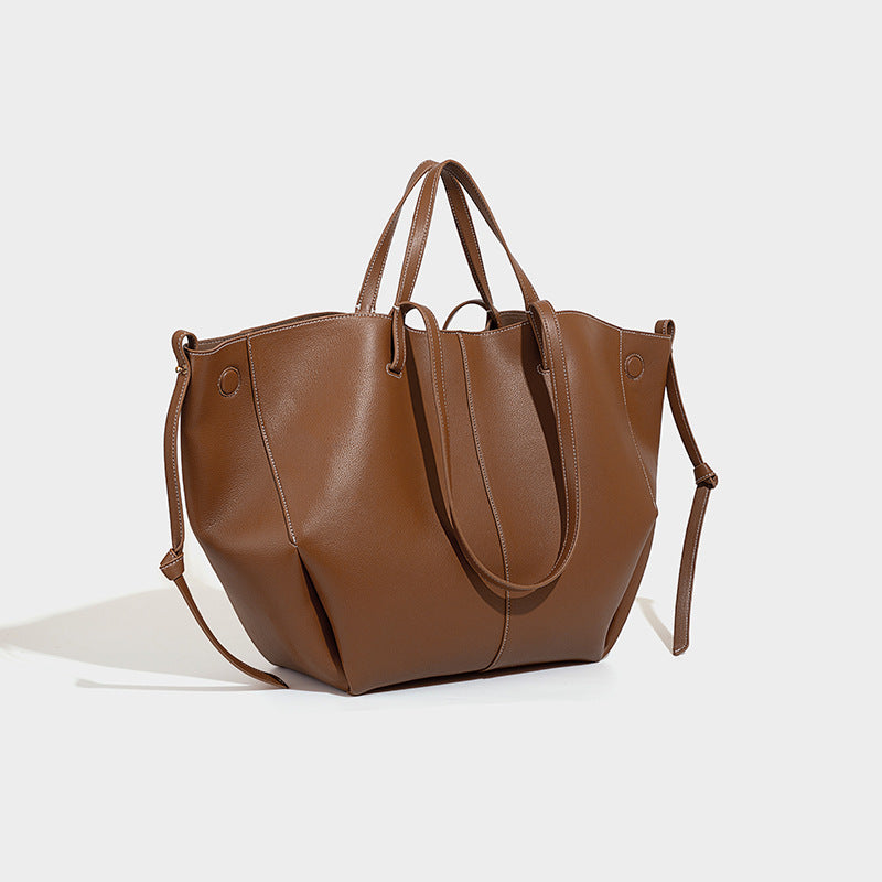 Large structured trapezoid tote bag in brown pebbled leather-look finish with double top handles and side tie straps, front