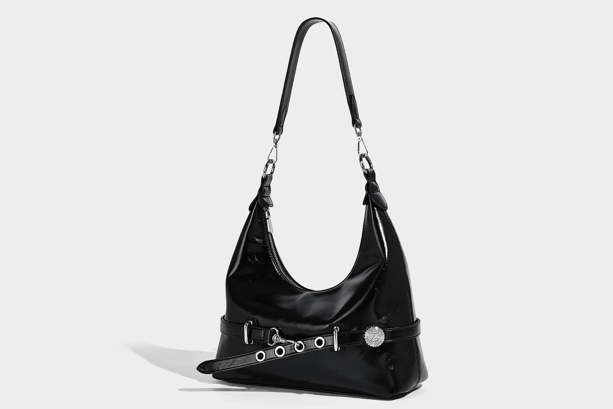 Glossy black slouchy hobo shoulder bag with silver-tone hardware, belt-style grommet strap at base, and long adjustable