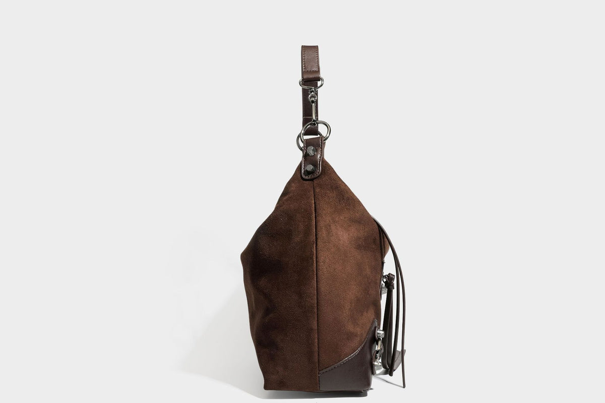 Slouchy suede-finish hobo shoulder bag with dark hardware, exterior zip pocket, tassel ties, and detachable crossbody strap