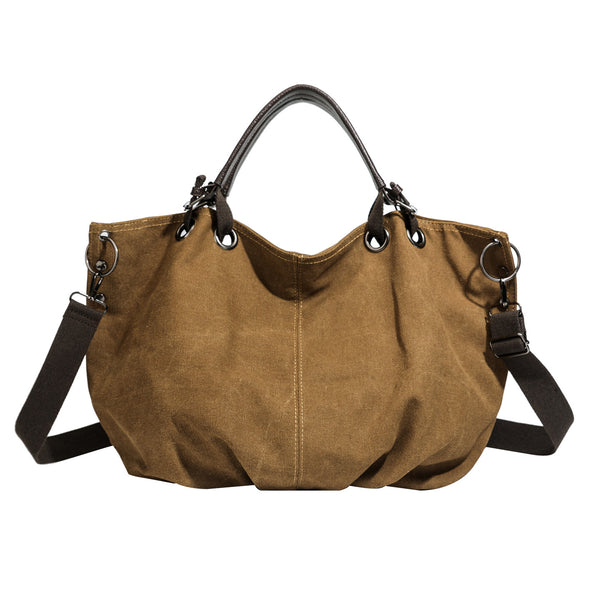 Slouchy matte canvas tote bag with dark dual top handles, metal grommet hardware, and detachable long shoulder strap, detail