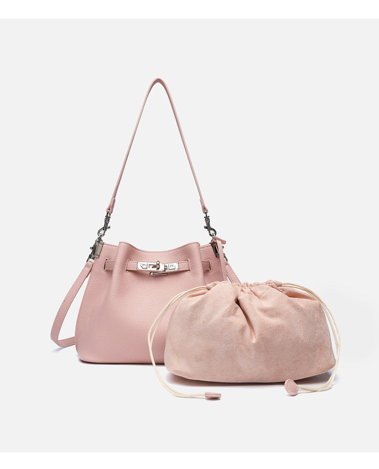 Soft-structured pebbled leather-look bucket bag with silver turn-lock front clasp and adjustable crossbody strap, detail view