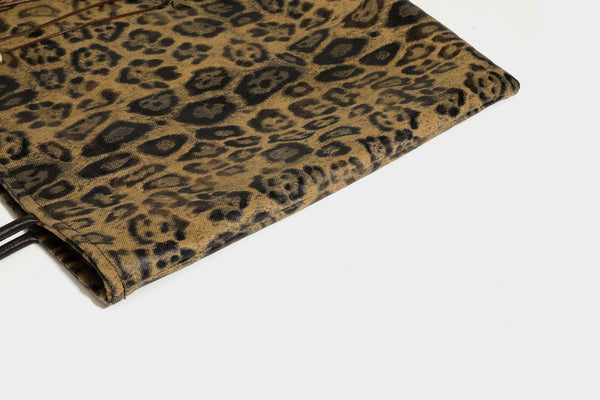 Large leopard print shoulder tote bag in tan and brown with slim dark straps and dangling beaded charm hardware, detail view