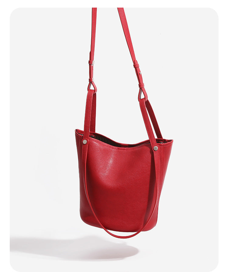 Large leather-look bucket tote bag with dual top handles and adjustable crossbody strap, detail view 8