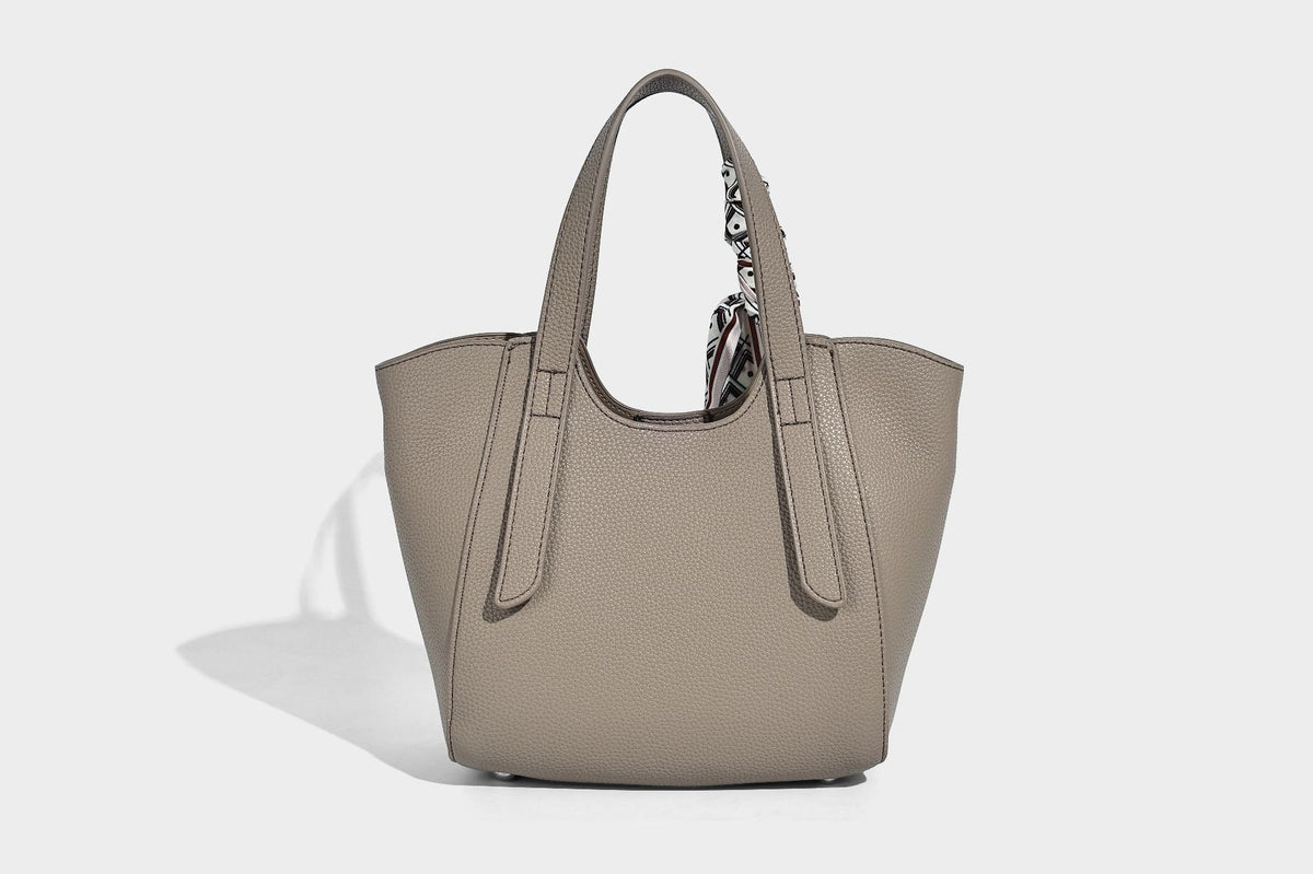 Structured pebbled leather-look tote bag with detachable scarf tie, dual top handles, and adjustable crossbody strap, detail