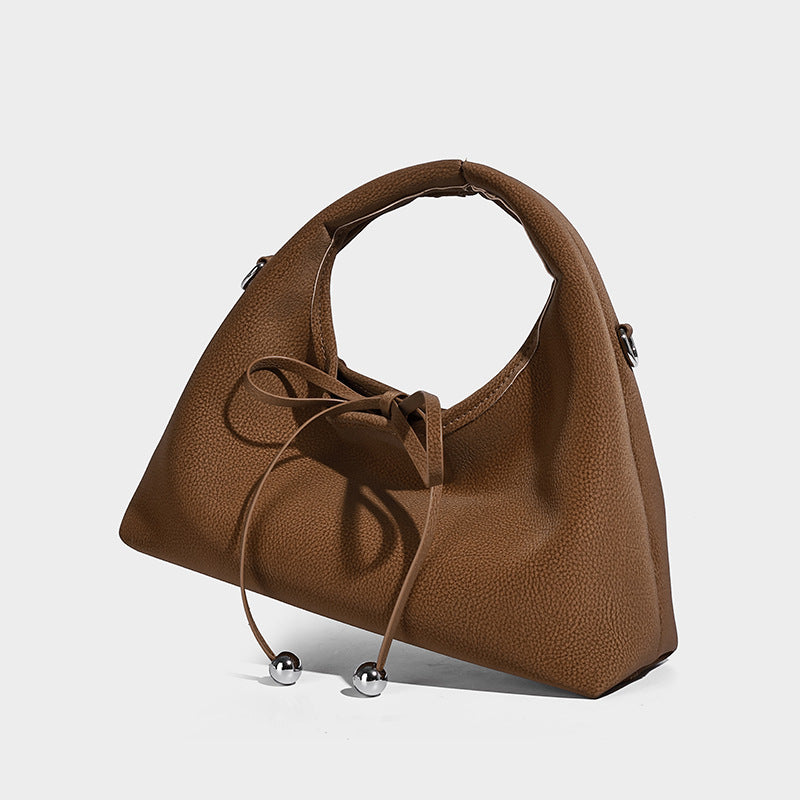 Pebbled matte trapezoid top-handle bag with drawstring bow closure, bead-tipped cords, silver-tone hardware, and detachable