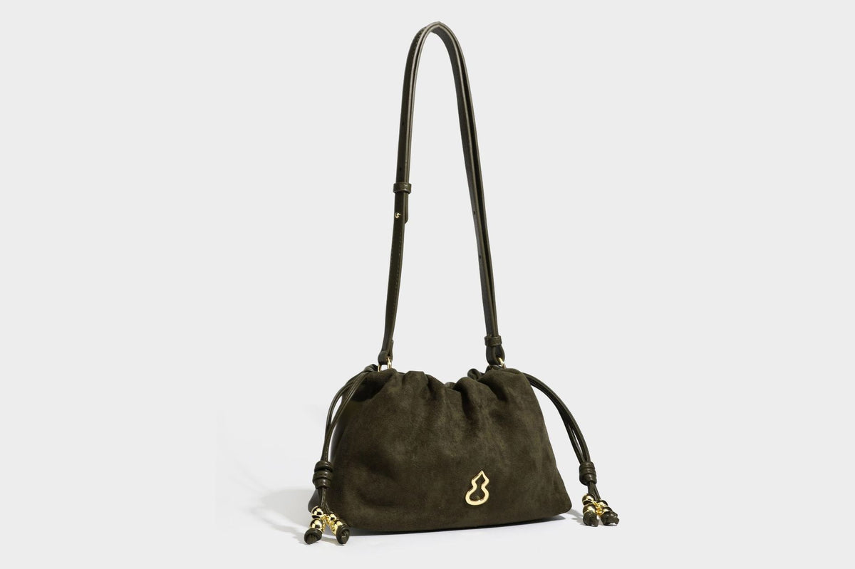 Suede-look drawstring shoulder bag in brown with smooth trim, knotted bead drawstring closure, slim adjustable strap, and