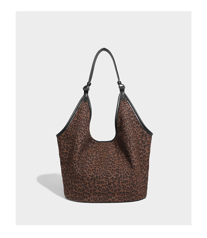 Slouchy brown leopard jacquard hobo tote bag with black leather-look trim and single shoulder strap, shown with black, detail