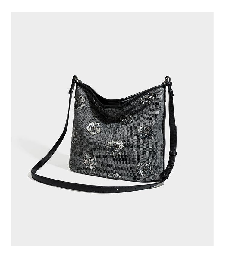 Lässig fallende Hobo-Schultertasche aus anthrazitfarbenem Webstoff mit floraler Stickerei aus silberfarbenen Pailletten, schwarzem Besatz in Lederoptik und langem
