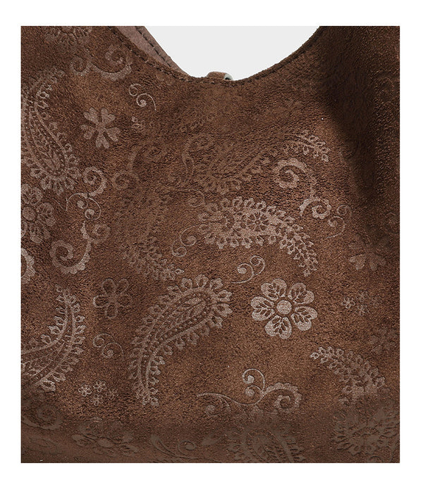 Slouchy boho hobo shoulder bag in embossed brown suede-look finish with beaded strap, cord tassels, and brass-tone leaf