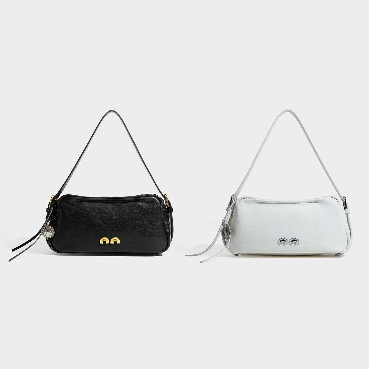 Compact black crinkled leather-look baguette shoulder bag with gold-tone arch hardware and adjustable strap, detail view 2
