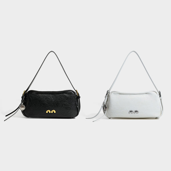 Compact black crinkled leather-look baguette shoulder bag with gold-tone arch hardware and adjustable strap, detail view 2