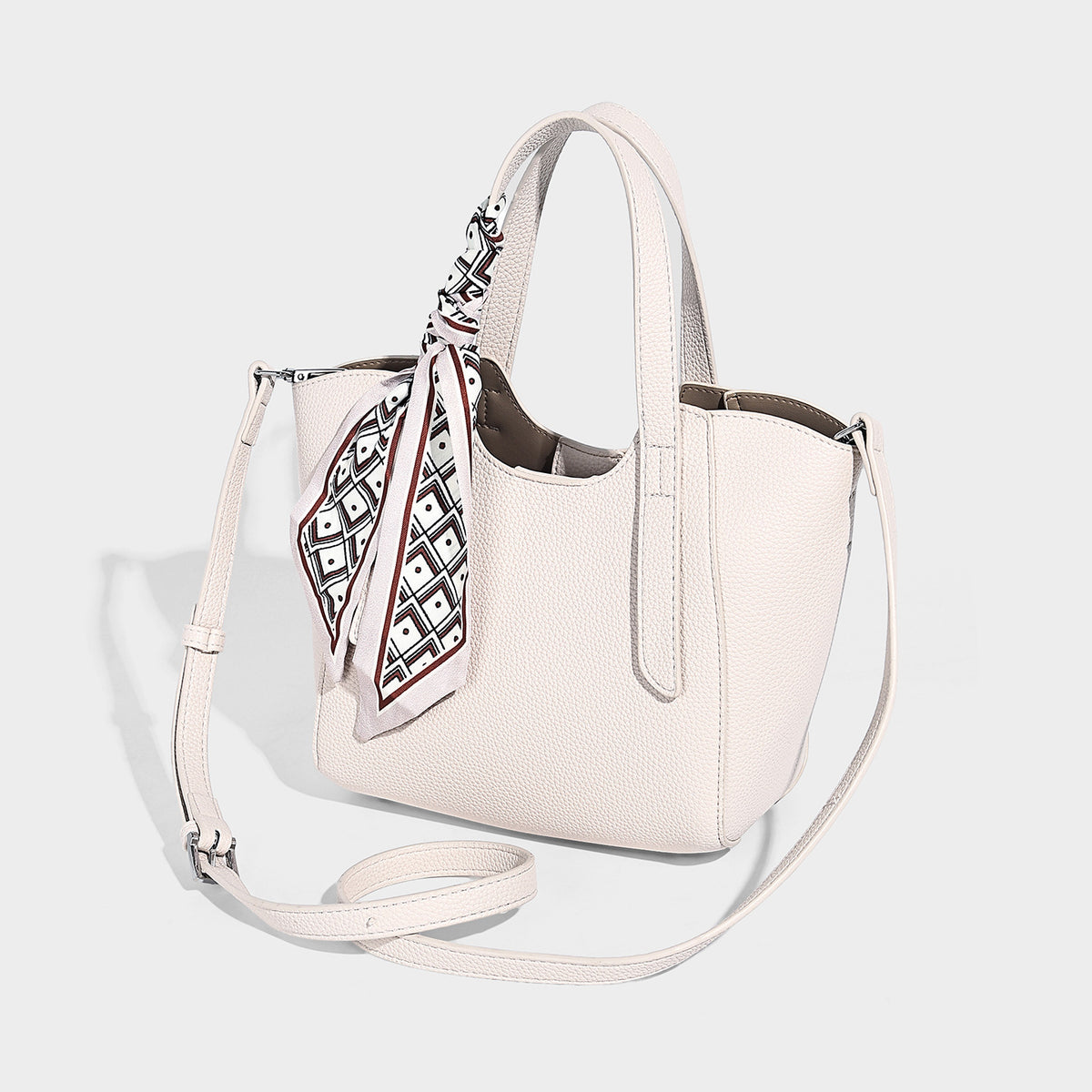Structured pebbled leather-look tote bag with detachable scarf tie, dual top handles, and adjustable crossbody strap, detail