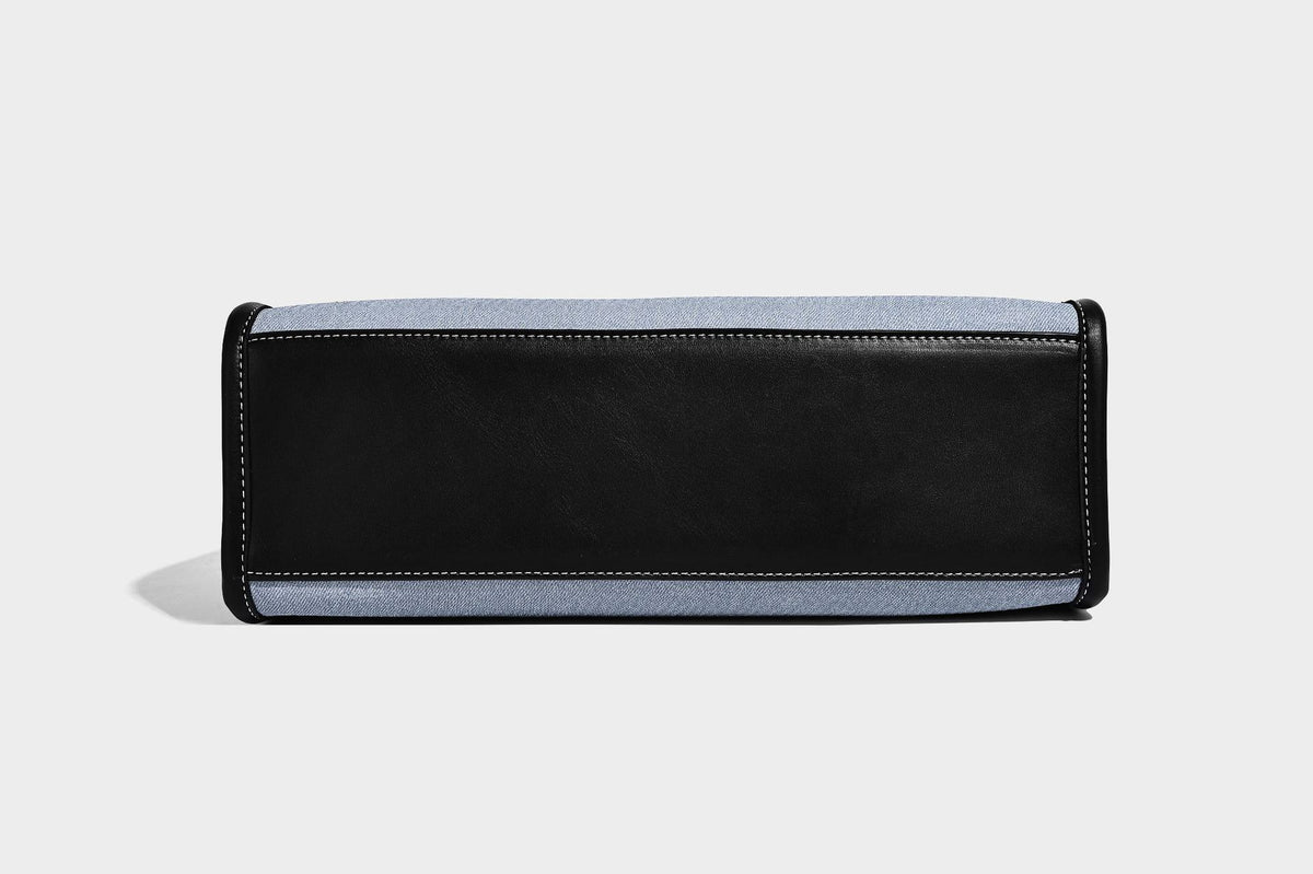Structured rectangular tote satchel in denim-look fabric with dark trim, knotted front strap hardware, and detachable, detail