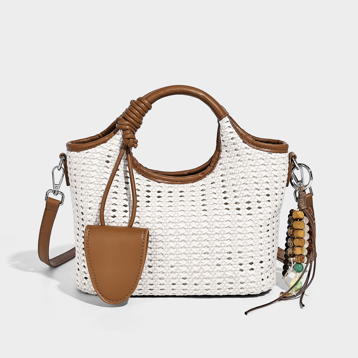Small structured woven tote crossbody bag with ring top handle, leather-look brown trim, front patch pocket, and detachable