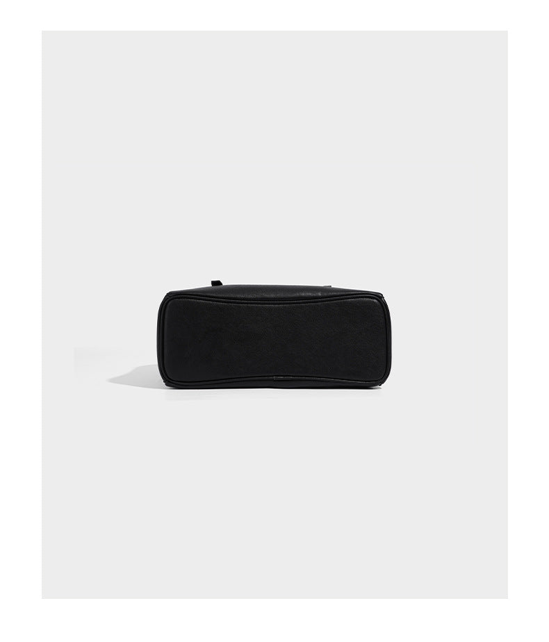 Structured dome-shaped shoulder bag with leather-look finish, top zipper closure, dual adjustable slim straps, and, detail