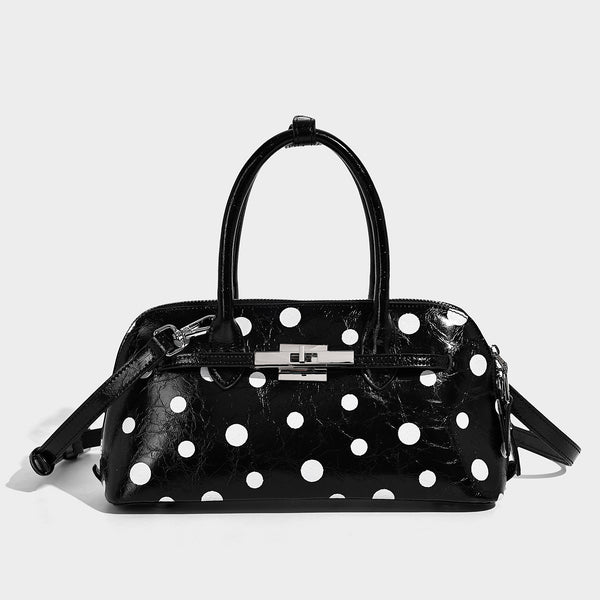 Structured polka-dot Boston bag with glossy crinkled finish, dual top handles, silver-tone turn-lock clasp, and detachable