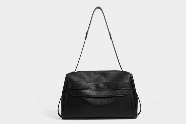 Strukturierte rechteckige dunkelbraune Schultertasche in Lederoptik mit Klappe, mehrlagigem Detail auf der Vorderseite und langem verstellbarem Riemen, Detailansicht