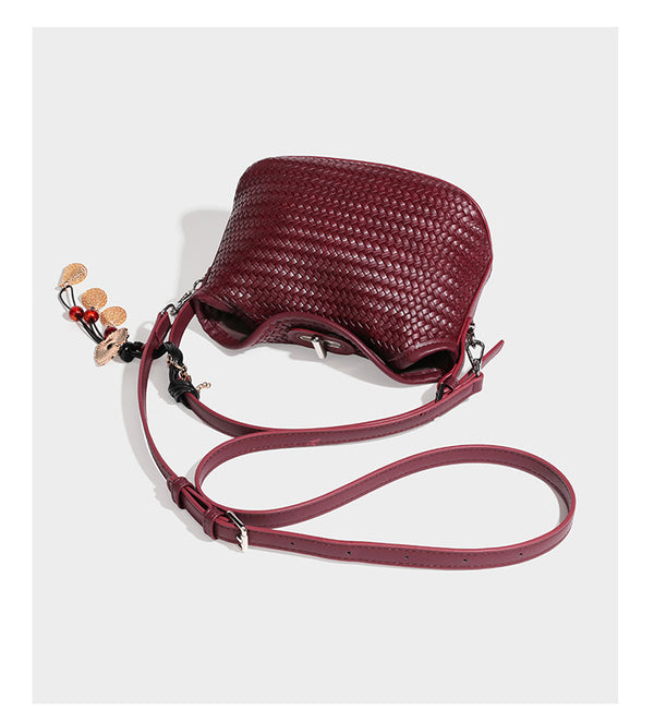 Small woven-look leather-look flap shoulder hobo bag in burgundy with silver-tone hardware and decorative tassel charm