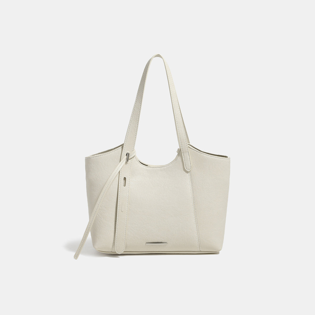 Structured trapezoidal tote bag with smooth leather-look finish, long black contrast shoulder straps, and dangling strap