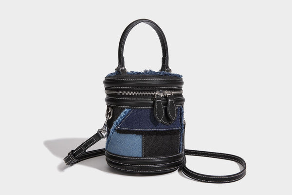 Mini cylindrical barrel bucket bag in denim patchwork with frayed edges, smooth leather-look trim, zip-around top closure