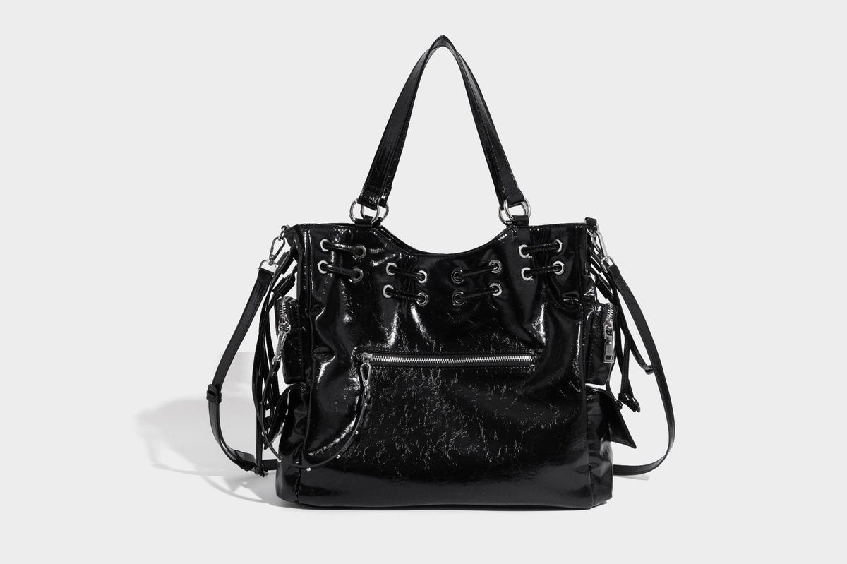 Glossy crinkled leather-look tote bag with silver grommet lace-up front detail, dual top handles, and detachable shoulder