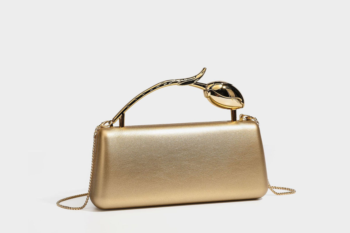Strukturierte rechteckige Clutch mit goldfarbenem Henkel in Form einer Rosenknospe und abnehmbarem Kettenriemen in Metallic-Optik, Detailansicht
