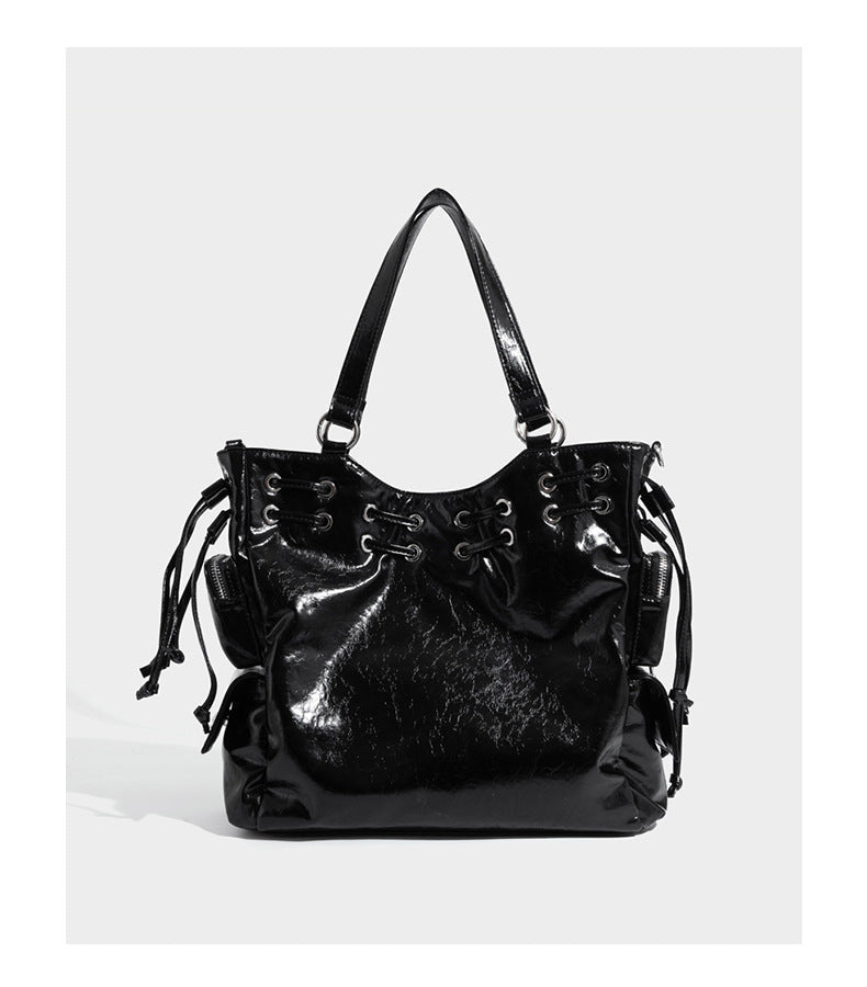 Glossy crinkled leather-look tote bag with silver grommet lace-up front detail, dual top handles, and detachable shoulder
