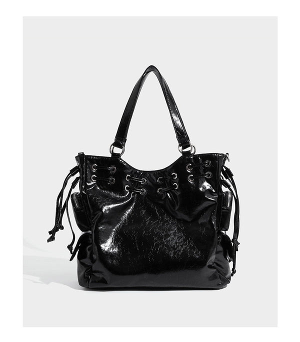 Glossy crinkled leather-look tote bag with silver grommet lace-up front detail, dual top handles, and detachable shoulder