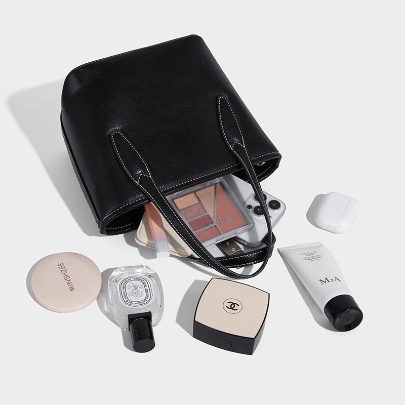Compact structured bucket tote bag with pebbled textured finish, dual top handles, silver-tone lock hardware, and detachable