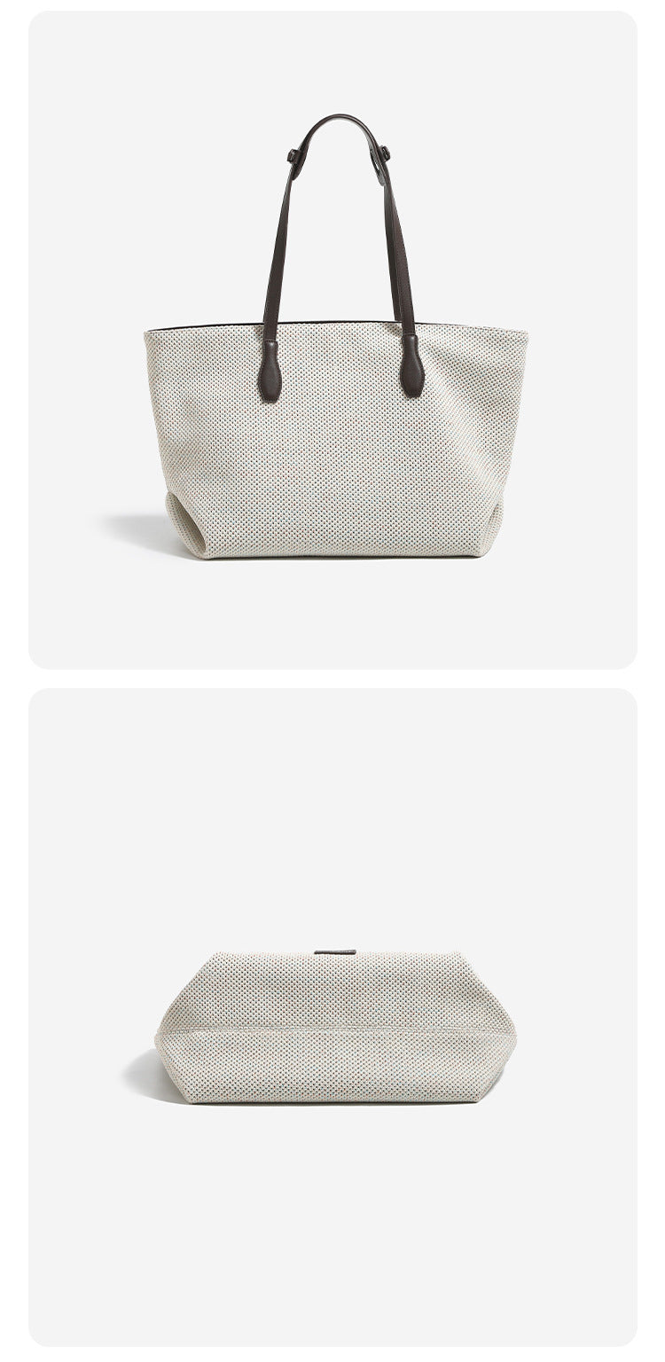 Off-white speckled woven tote bag with dark brown leather-look shoulder straps, zip closure, and hanging rectangular tag
