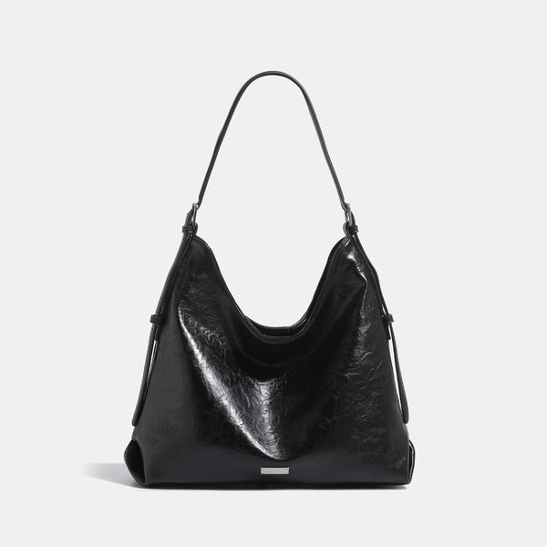Slouchy hobo shoulder bag with glossy wrinkled leather-look finish, adjustable strap, and snap closure, front view