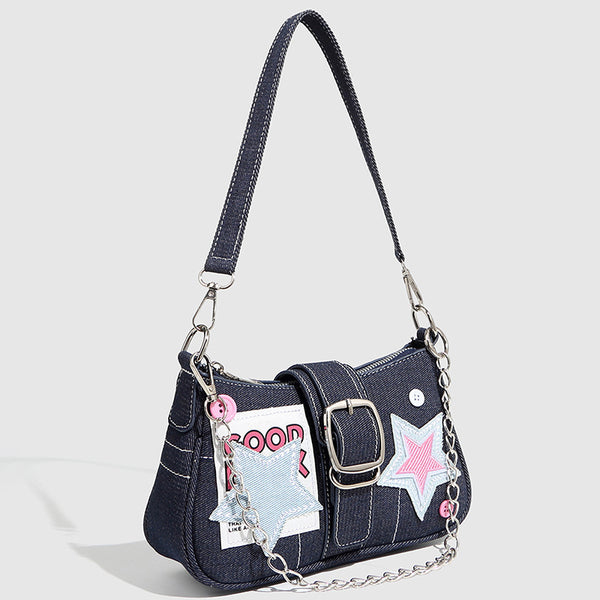 Dark navy denim-look shoulder bag with light blue and pink star appliqués, silver-tone buckle, chain strap, and short top