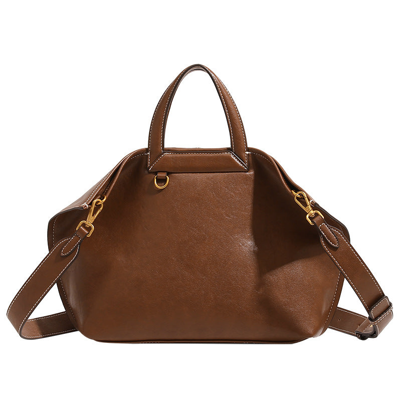 Structured cognac brown leather-look tote bag with fold-ear side panels, top handles, gold-tone hardware, and detachable