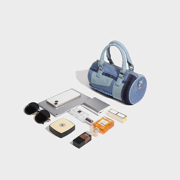 Mini barrel handbag in light and dark denim patchwork with frayed seam trim, dual top handles, top zip closure, and, detail