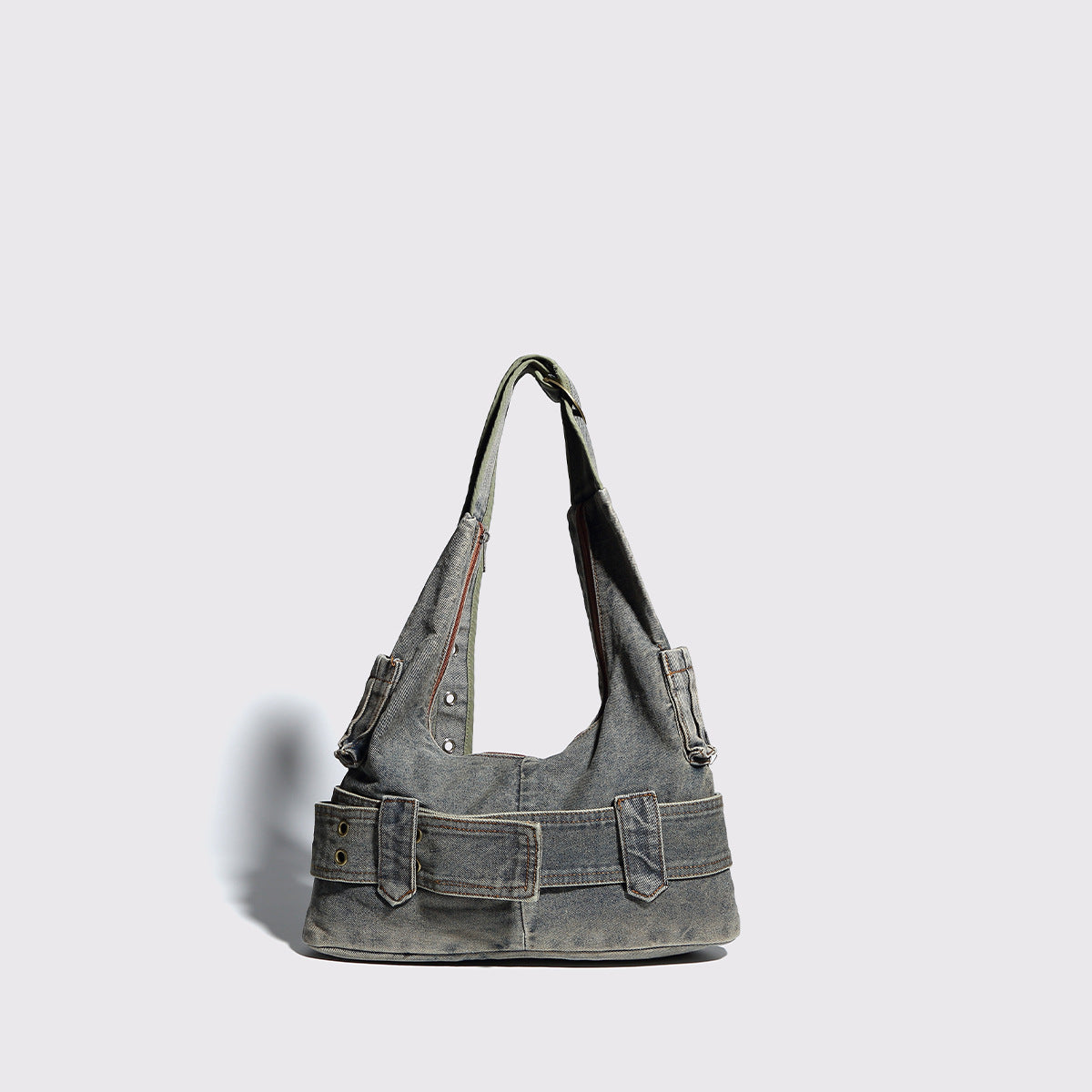 Washed faded denim hobo shoulder bag with wide brass-tone buckle belt panel, eyelet detailing, front zip pocket, and dual
