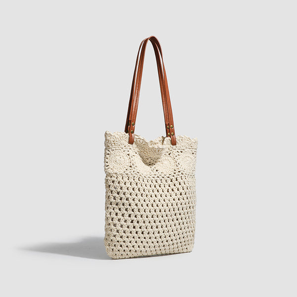 Woven crochet shoulder tote bag with scalloped floral top edge, tan leather-look straps, and antique gold rivets, detail view
