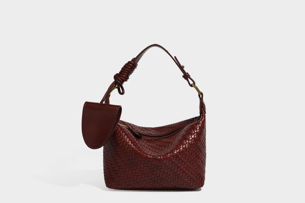 Small glossy basket-weave hobo shoulder bag in brown with knotted top handle, flap accent pocket, and gold-tone hardware