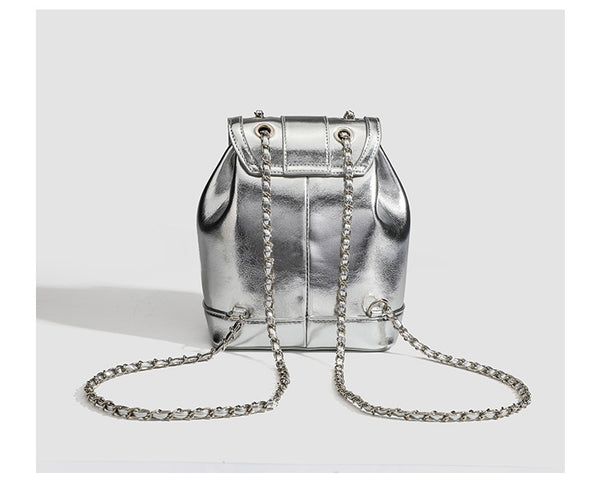 Kompakter Rucksack in Silbermetallic mit mehrfarbigen Kristallnieten, runder Klappe mit Drehverschluss und ineinander verflochtenem Silber