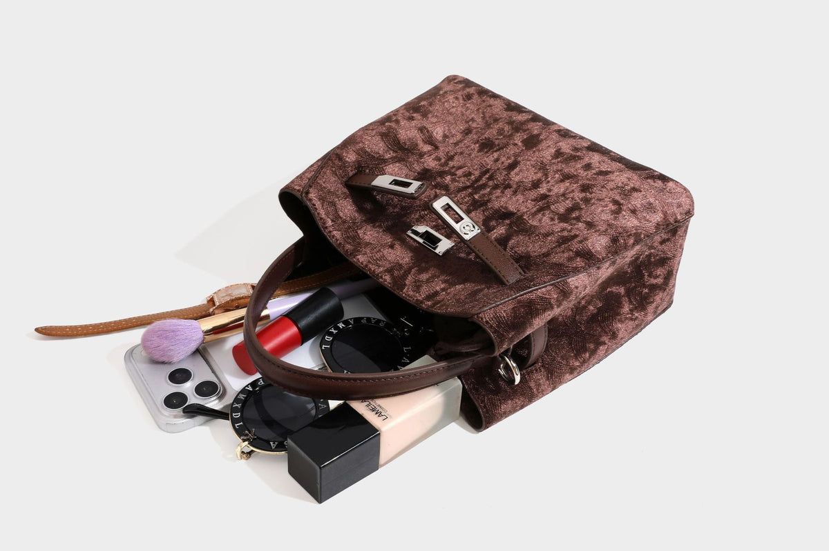 Small structured bucket satchel in embossed velvet-texture fabric with silver turn-lock hardware, rounded top handle, and