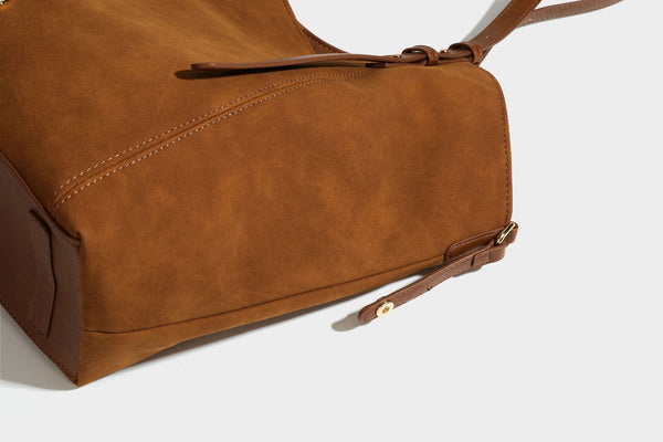 Oversized suede-finish tote shoulder bag in caramel brown with slim leather-look straps and gold-tone logo hardware, detail