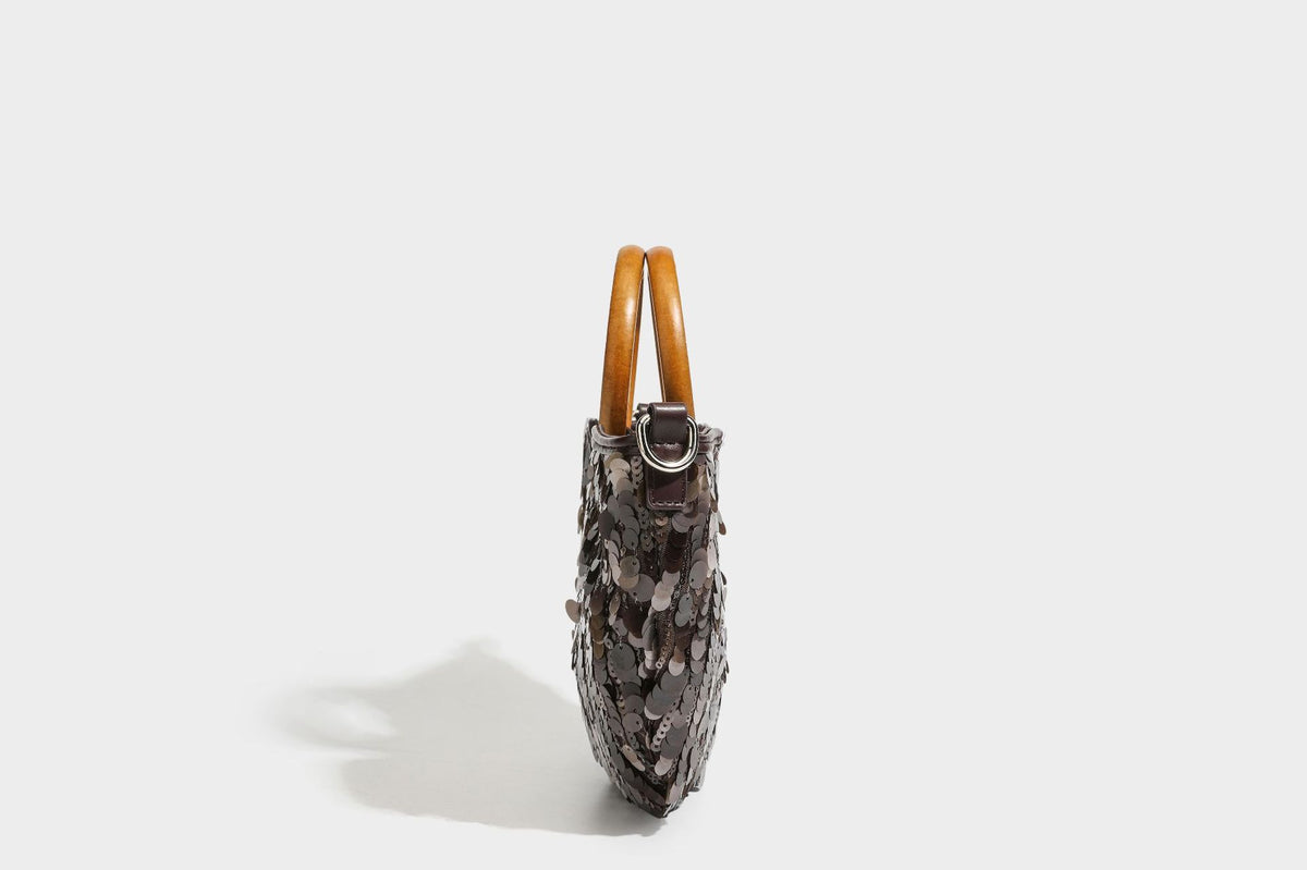 Small sequin half-moon handbag with circular wood-look ring handles and detachable leather-look shoulder strap, detail view
