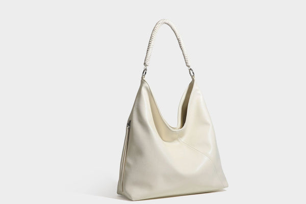 Large slouchy hobo shoulder bag with braided top handle, smooth glossy leather-look finish, and silver-tone ring hardware