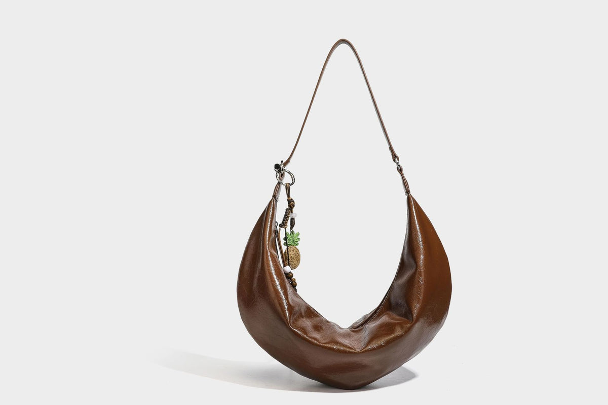 Lässig fallende Hobo-Schultertasche in Halbmondform mit glänzender, geknautschter Lederoptik, schmalem Riemen, silberfarbenen Ringbeschlägen und