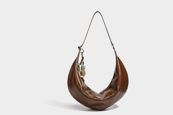 Lässig fallende Hobo-Schultertasche in Halbmondform mit glänzender, geknautschter Lederoptik, schmalem Riemen, silberfarbenen Ringbeschlägen und